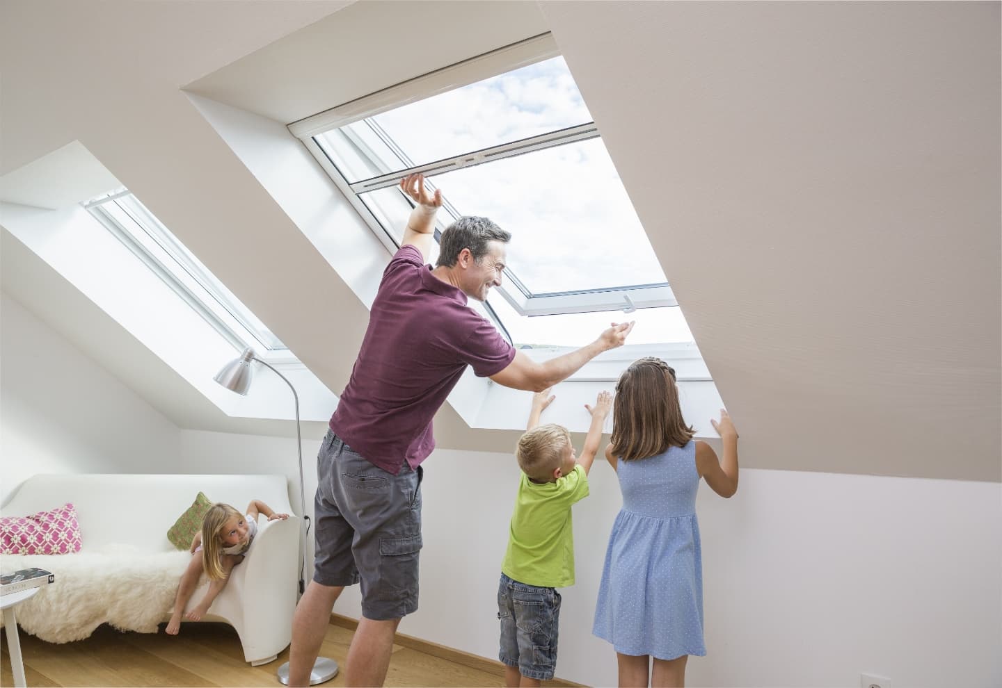 Familie öffnet ein Dachfenster mit Insektenschutz